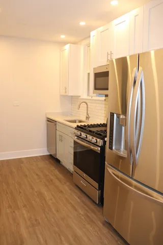 a kitchen with stainless steel appliances granite countertop a refrigerator a sink and a stove