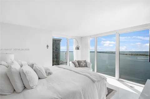 a bedroom with a large bed and a large window