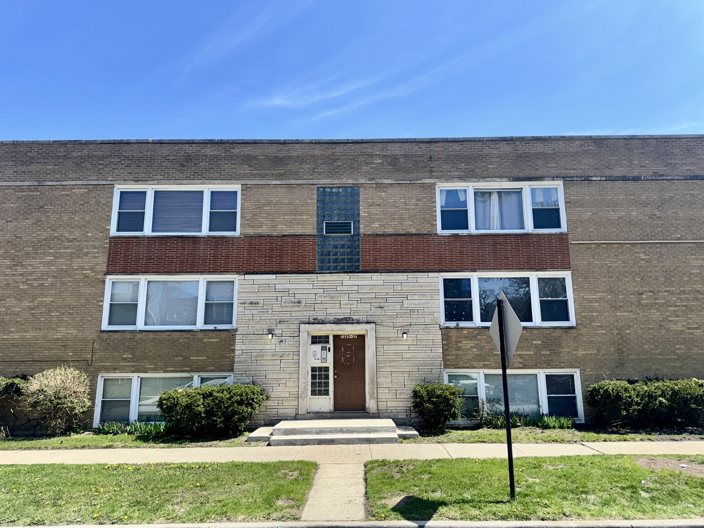 7325 South Kingston Avenue, Unit 2 Chicago, IL 60649 - Photo 2 of 13 a view of a brick house with a yard