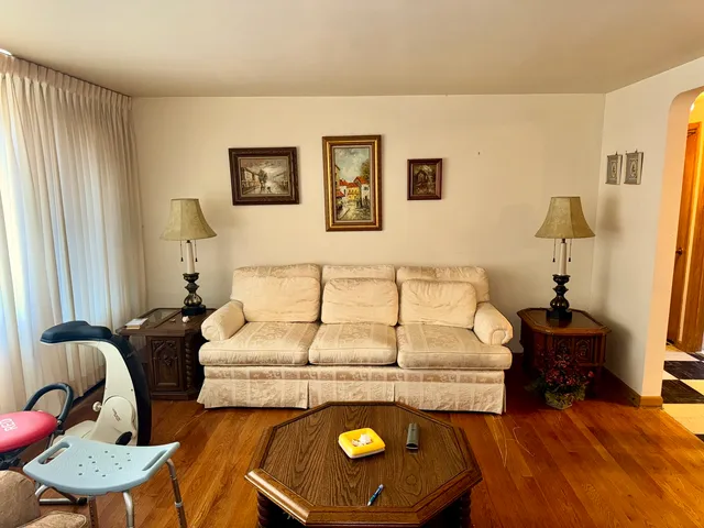 a bed room with a bed mirror and a chair