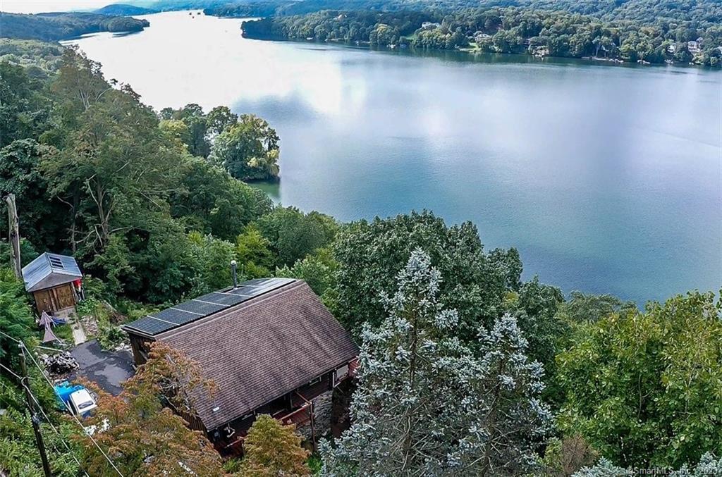 an aerial view of a house with a yard and lake view