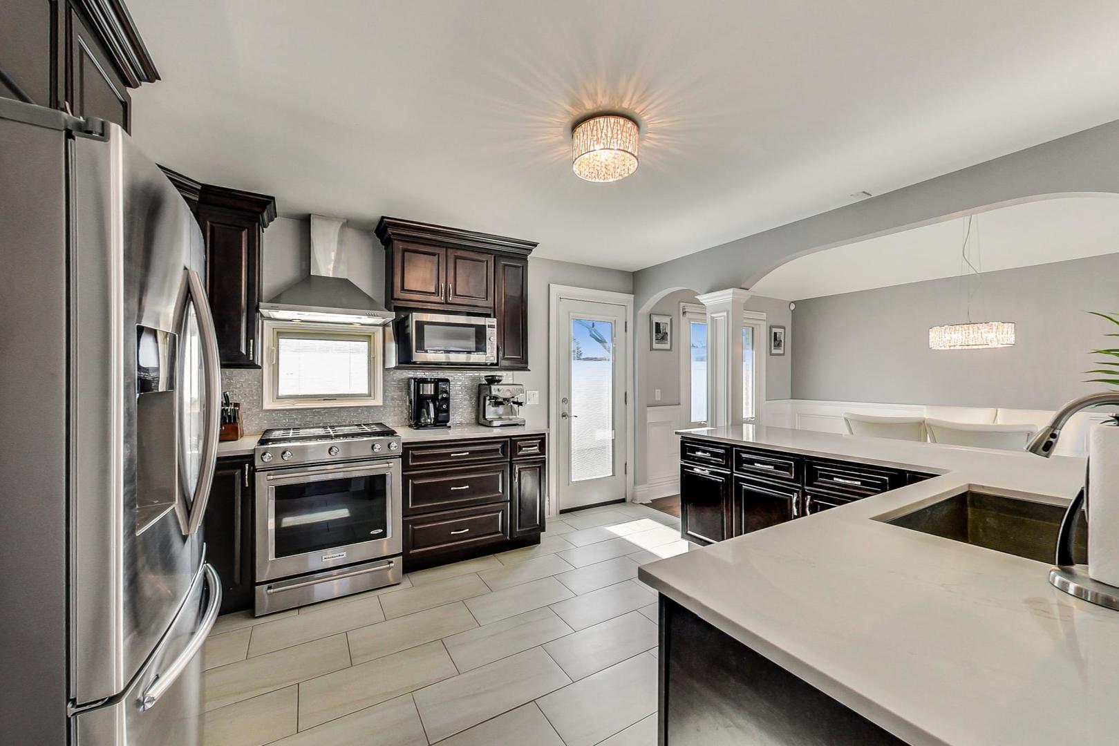 1579 West Holtz Avenue Addison, IL 60101 - Photo 12 of 43 a kitchen with stainless steel appliances a stove a sink and a refrigerator