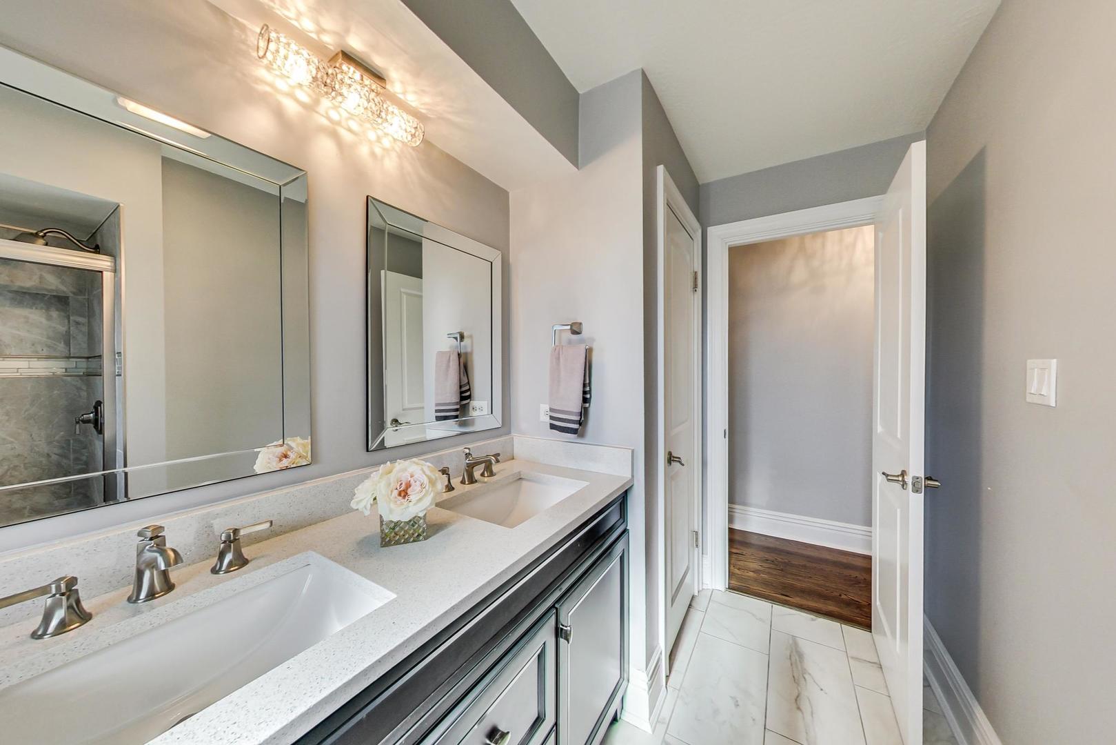1579 West Holtz Avenue Addison, IL 60101 - Photo 20 of 43 a en suite bathroom with a double vanity sink and a mirror