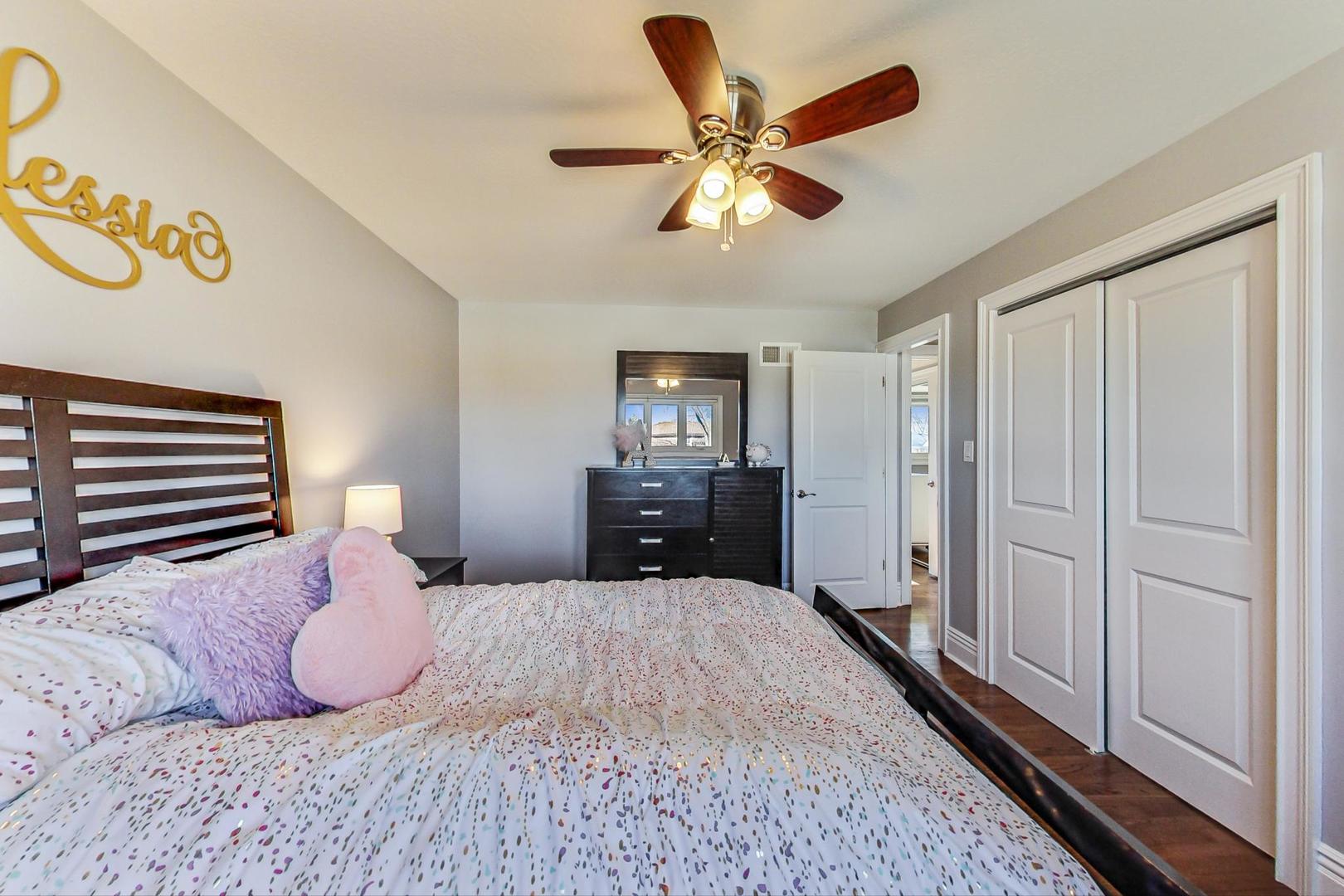 1579 West Holtz Avenue Addison, IL 60101 - Photo 22 of 43 a bedroom with a large bed and a chandelier