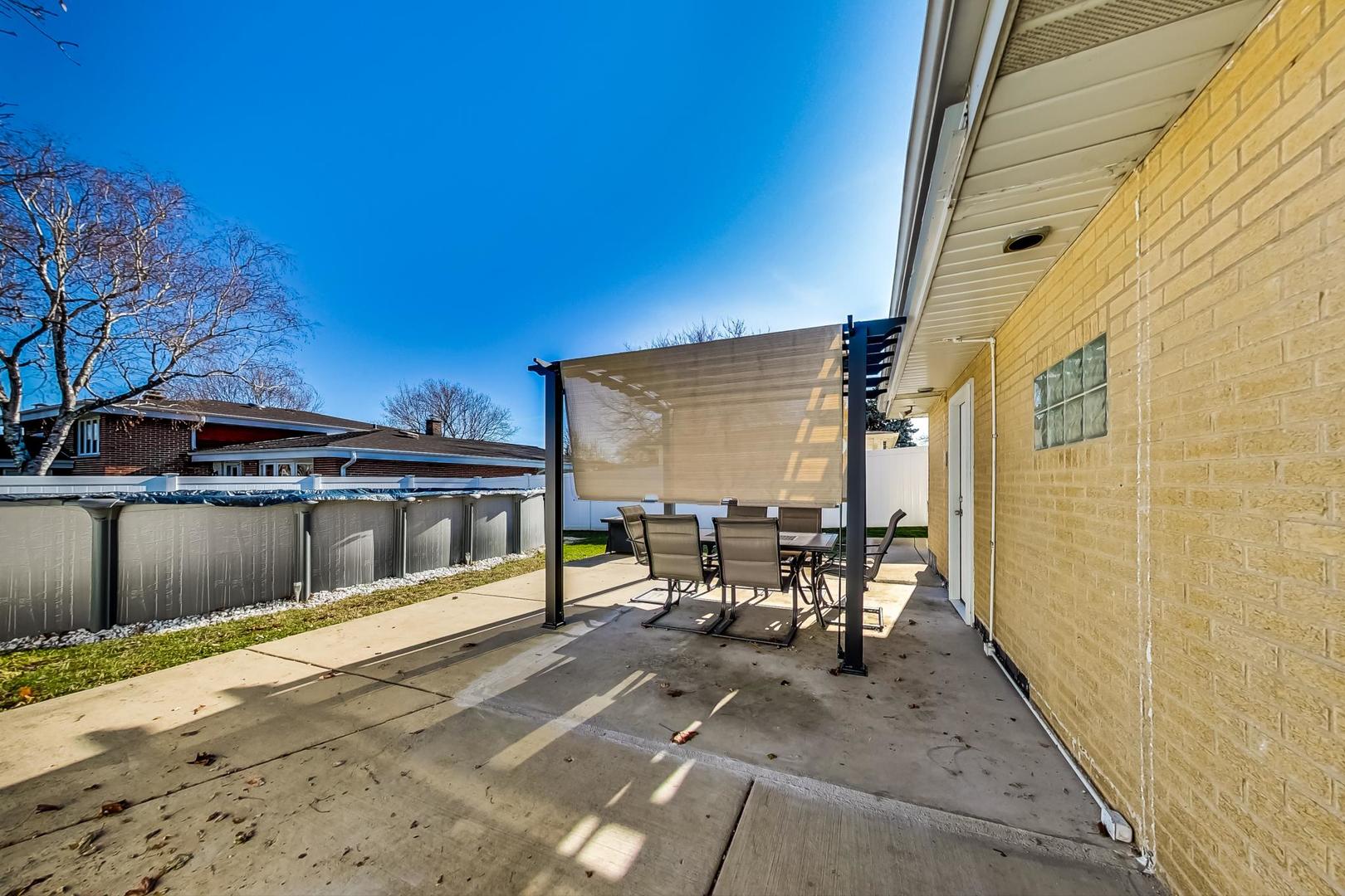 1579 West Holtz Avenue Addison, IL 60101 - Photo 36 of 43 a view of a patio with table and chairs near a yard