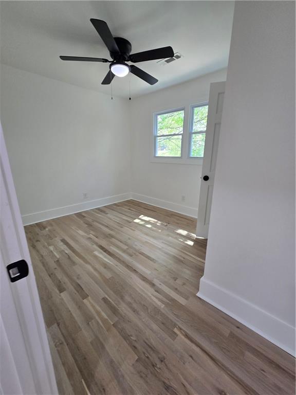 3832 Finger Creek Southwest Lilburn, GA 30047 - Photo 15 of 24 an empty room with wooden floor fan and windows