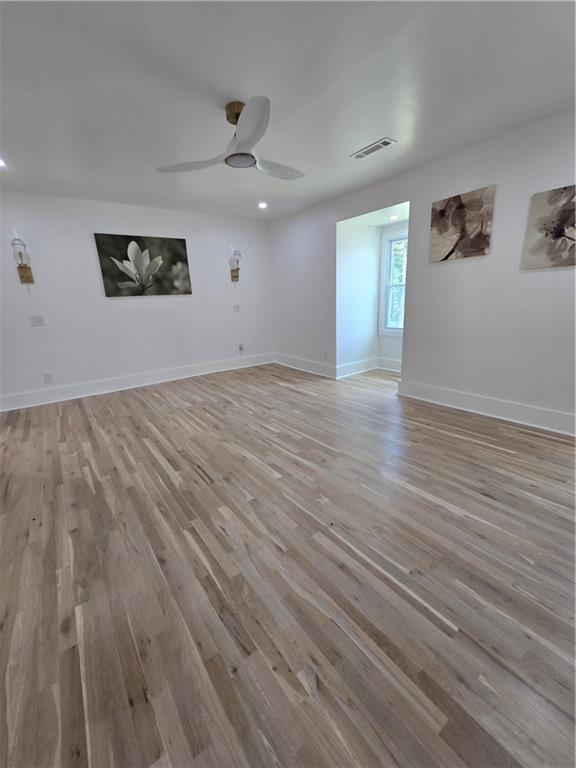 3832 Finger Creek Southwest Lilburn, GA 30047 - Photo 19 of 24 an empty room with wooden floor chandelier fan and windows