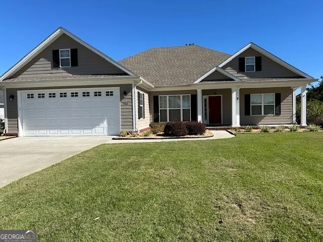 a front view of a house with a yard garden and outdoor seating