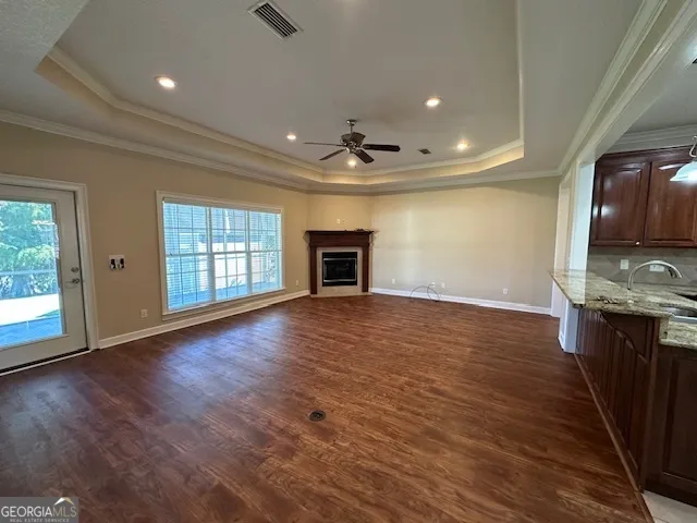 a kitchen with kitchen island granite countertop wooden cabinets a refrigerator and a sink