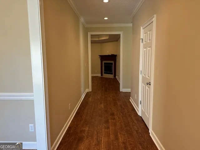 an empty room with wooden floor fireplace and windows