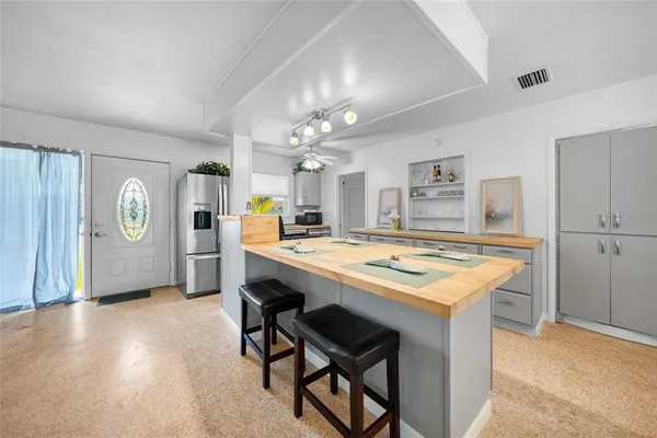 a kitchen with kitchen island a stove and a refrigerator