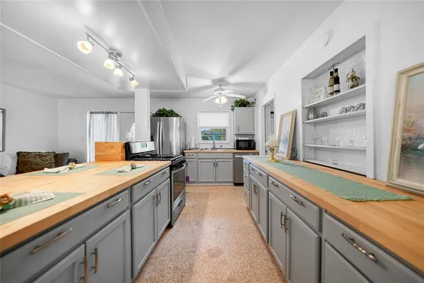a large kitchen with a large counter top a sink a stove and a refrigerator