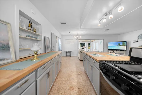 a large kitchen with stainless steel appliances granite countertop a lot of counter space and wooden floors