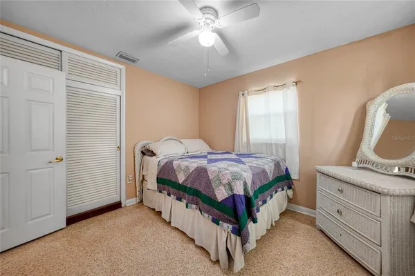 a spacious bedroom with a bed and a chandelier