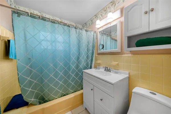 a bathroom with a sink a toilet a mirror and shower