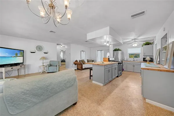 a large white kitchen with lots of counter space a sink and appliances