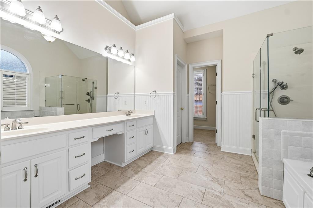 3051 Glenview Lane Monroe, GA 30656 - Photo 15 of 44 a spacious bathroom with a double vanity sink a large mirror a shower and bathtub