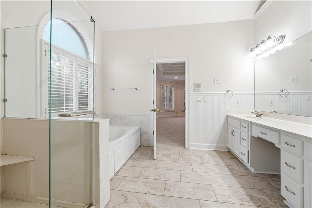 3051 Glenview Lane Monroe, GA 30656 - Photo 16 of 44 a spacious bathroom with a double vanity sink a mirror and a bathtub
