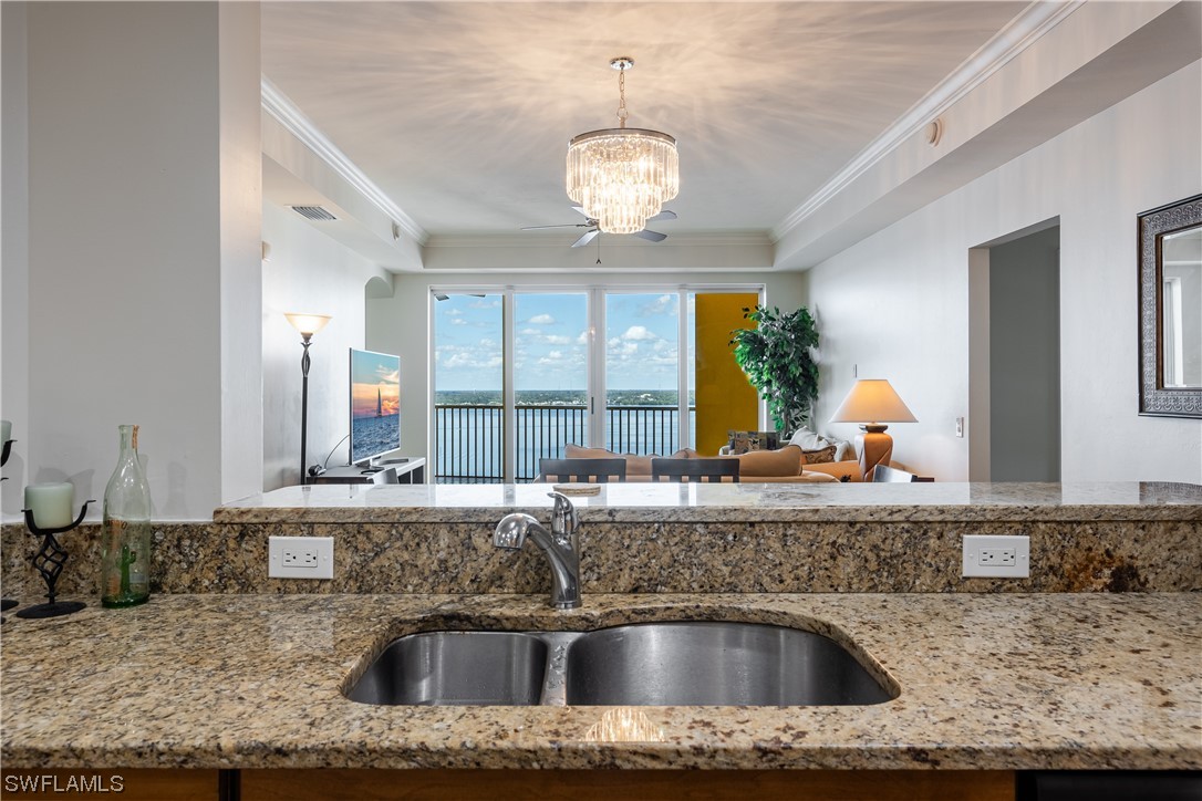 2743 First Street, Unit 1604 Fort Myers, FL 33916 - Photo 13 of 41 a kitchen with kitchen island granite countertop a sink and a large mirror