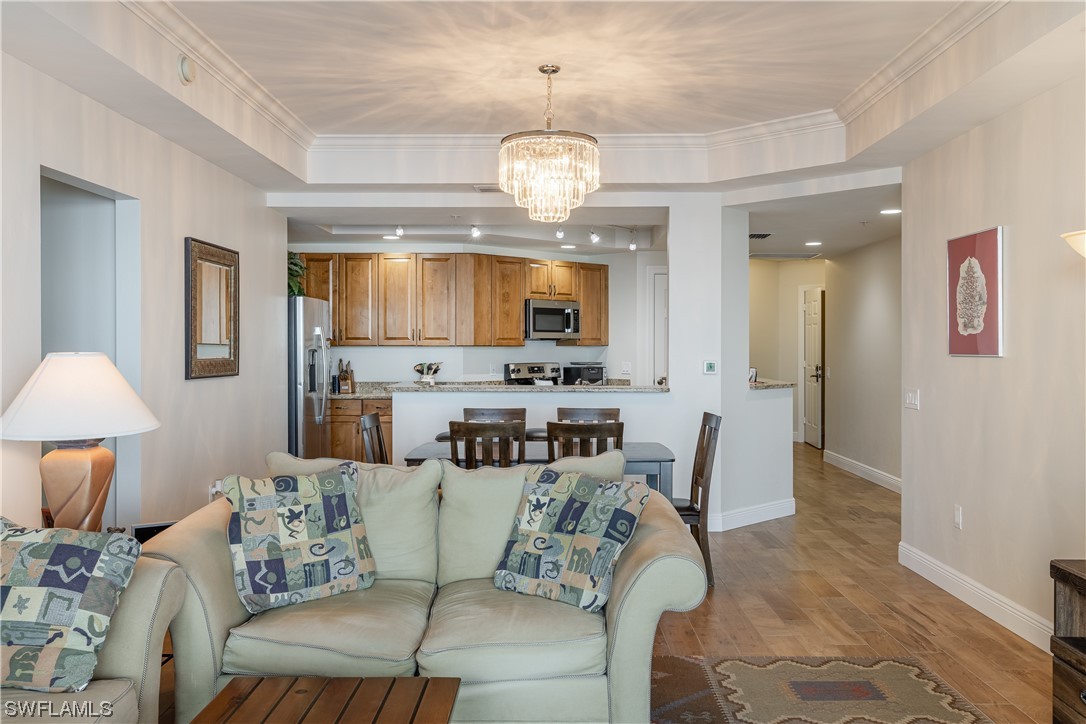 2743 First Street, Unit 1604 Fort Myers, FL 33916 - Photo 15 of 41 a living room with furniture a chandelier and a dining room