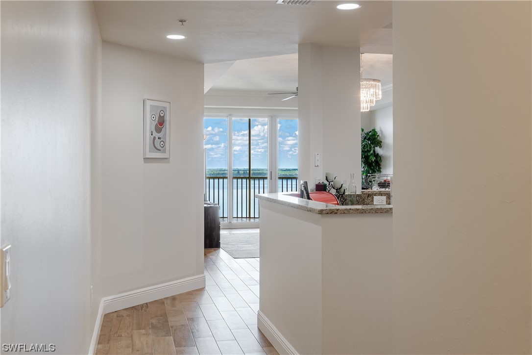 2743 First Street, Unit 1604 Fort Myers, FL 33916 - Photo 8 of 41 a view of a hallway and a dining room with wooden floor