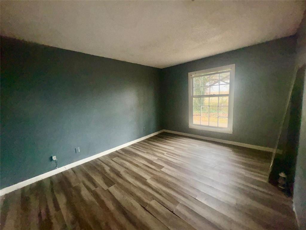 85 Place Fontaine Lithonia, GA 30038 - Photo 6 of 11 an empty room with wooden floor and windows