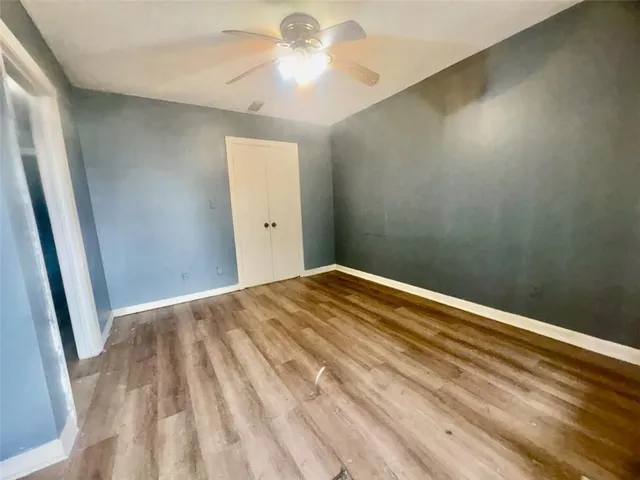 a view of an empty room with wooden floor