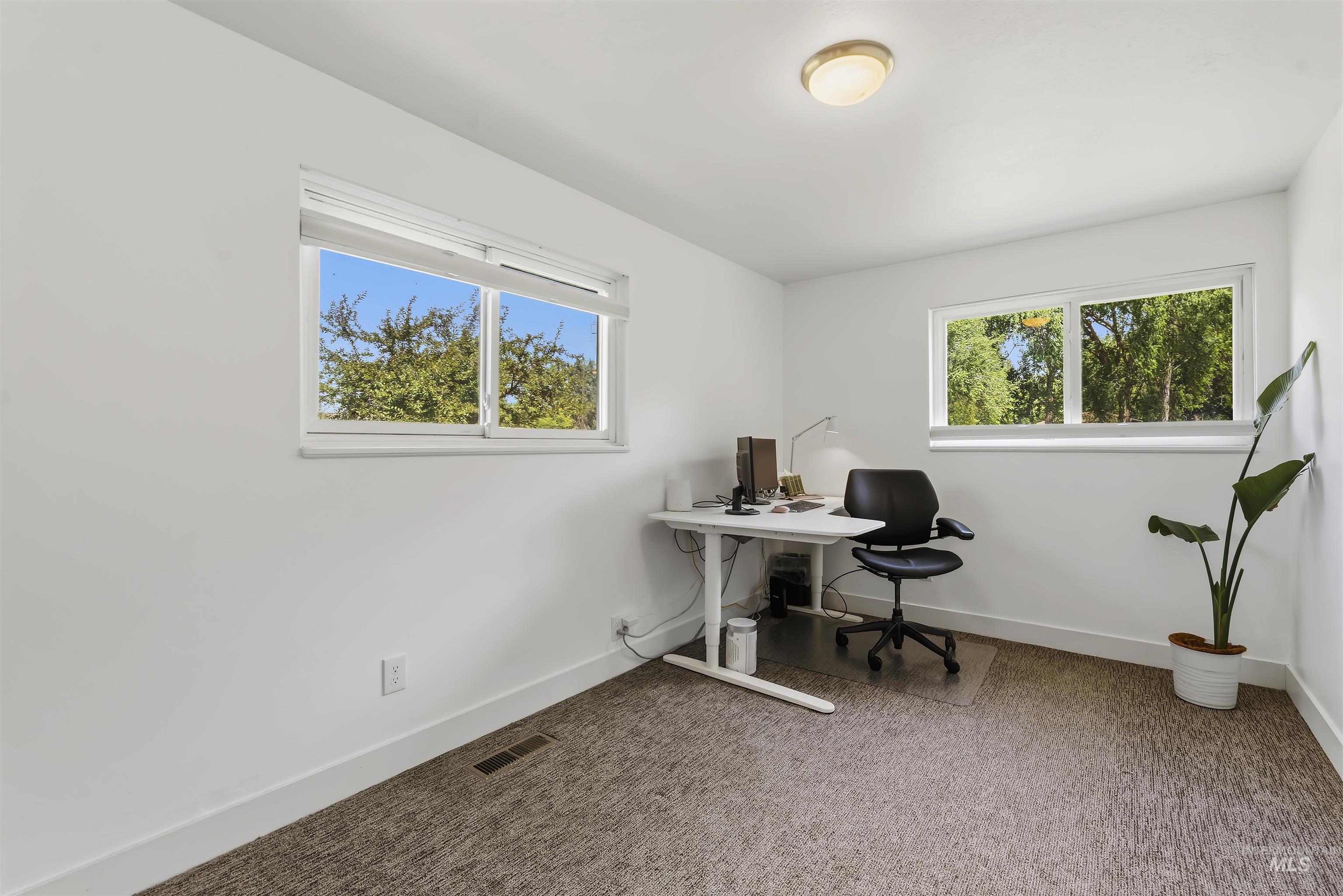 355 East Beacon Light Road Eagle, ID 83616 - Photo 24 of 47 Bright room featuring two windows with white frames, a flush-mount ceiling light, white baseboards, and textured carpeting