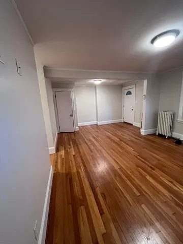 a view of a room with wooden floor and cabinets