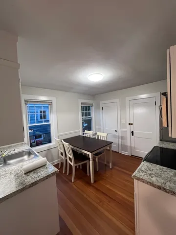 a living room with stainless steel appliances granite countertop furniture and wooden floors