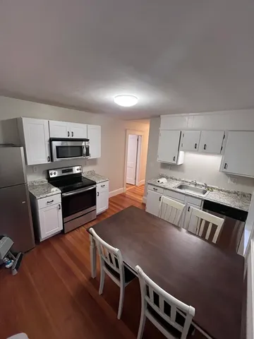 a kitchen with stainless steel appliances a stove a sink a microwave and cabinets