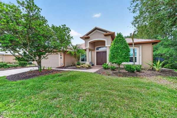 a front view of a house with a yard and trees