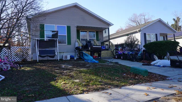 a view of a house that has a small yard and large trees