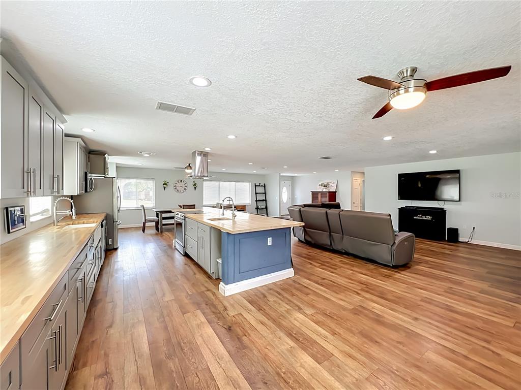 153 Variety Tree Circle Altamonte Springs, FL 32714 - Photo 12 of 44 a large kitchen with stainless steel appliances kitchen island a large counter top a stove and a wooden floors