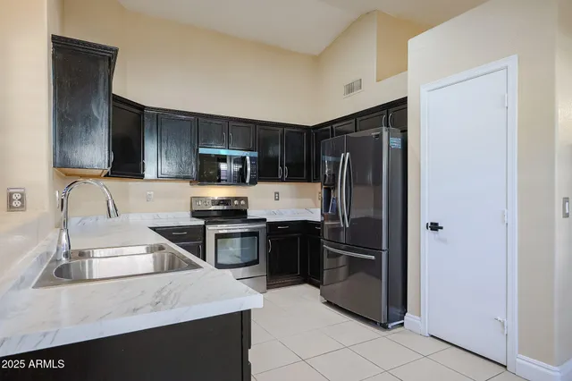 a kitchen with granite countertop stainless steel appliances and a refrigerator