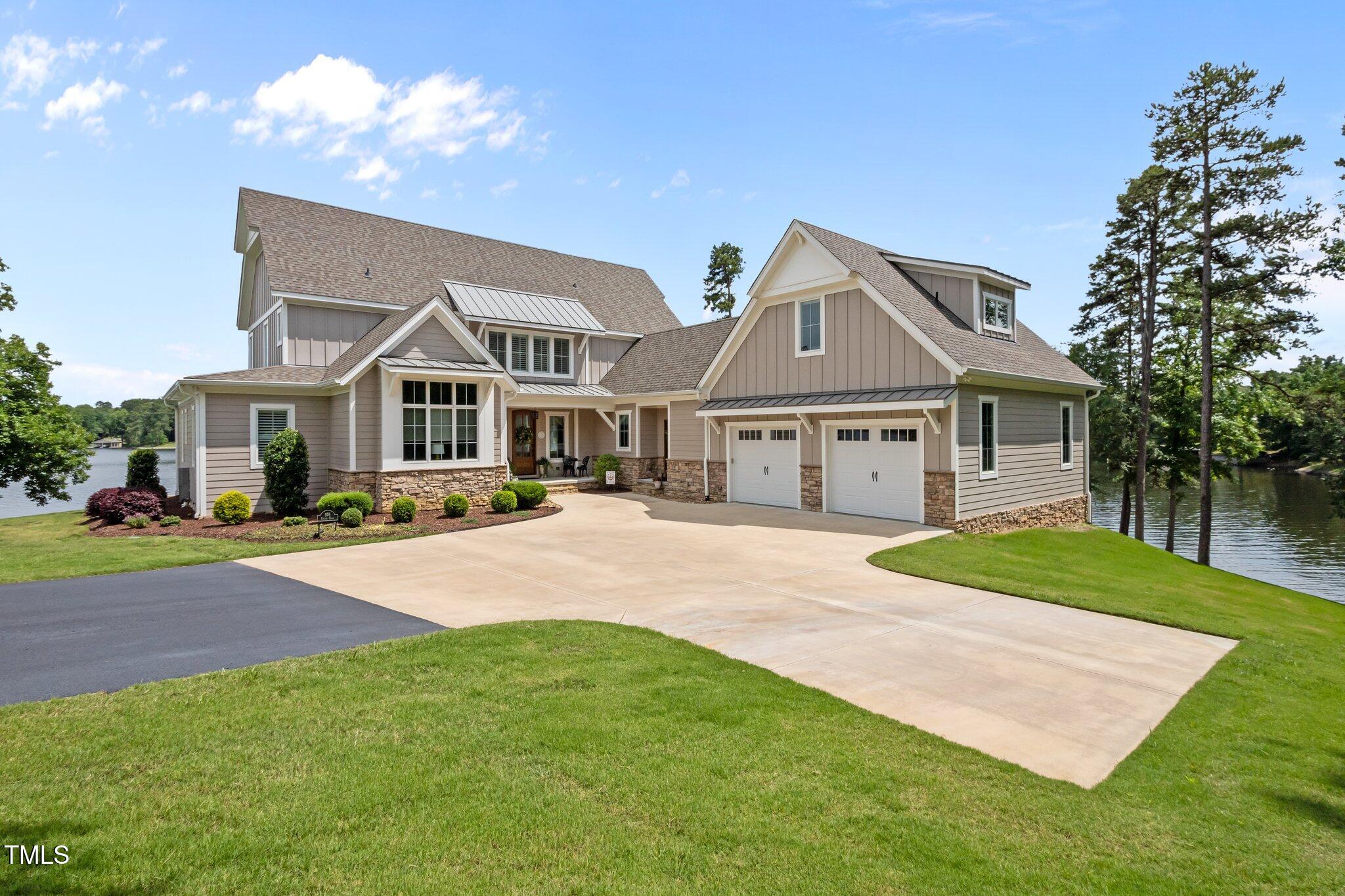 a front view of a house with yard and green space