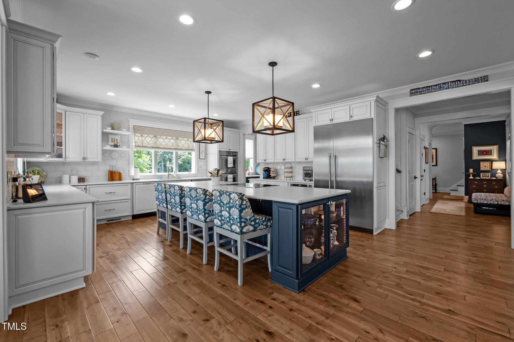 976 Estate Road Semora, NC 27343 - Photo 23 of 69 a kitchen with stainless steel appliances granite countertop wooden floors a stove and a sink