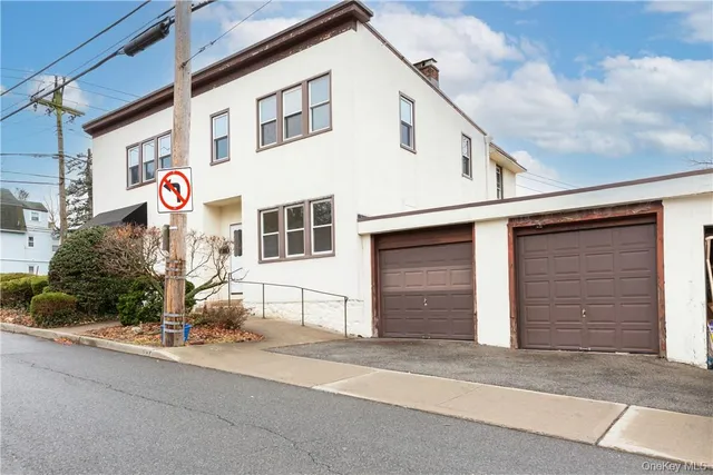 a front view of a white building with red door