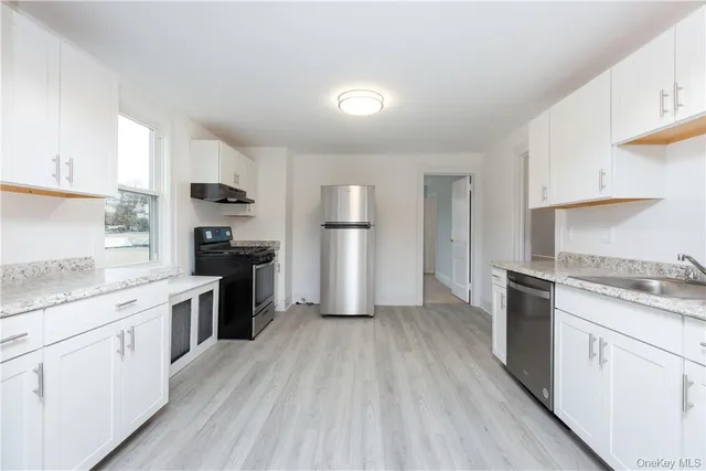 a kitchen with a refrigerator a stove top oven and sink