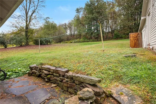 a view of a house with a yard and sitting area