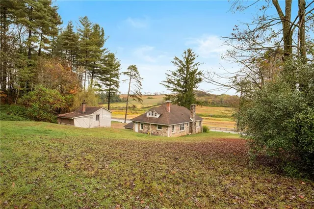 a view of an house with backyard and trees