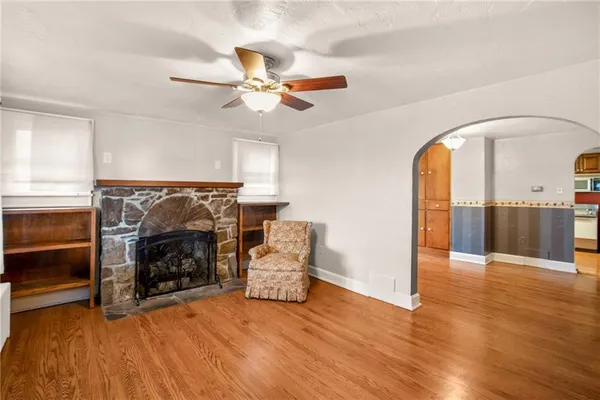 a view of an empty room with furniture a fireplace and wooden floor