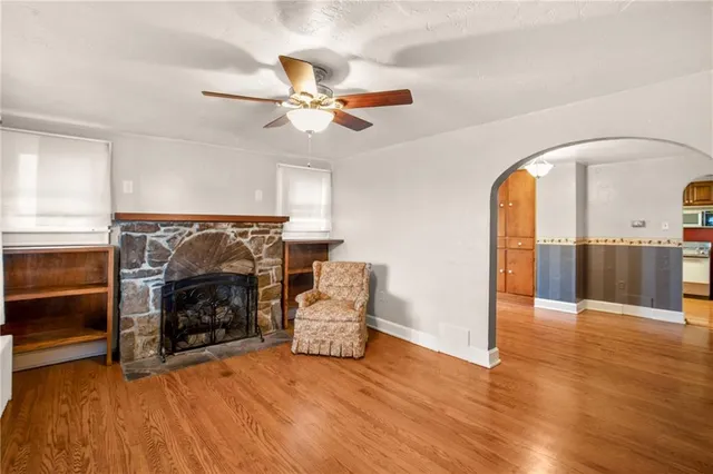 a view of an empty room with furniture a fireplace and wooden floor