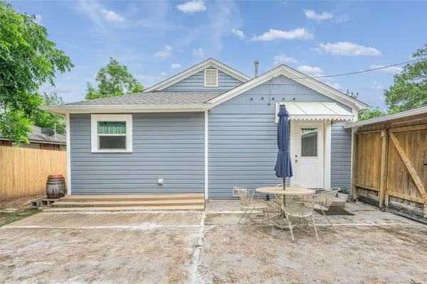 a backyard of a house with table and chairs