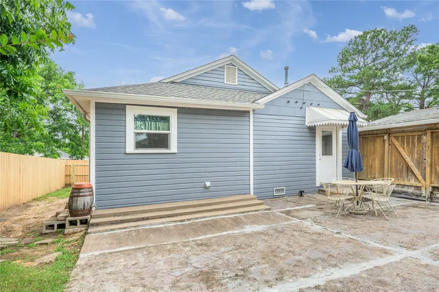 a backyard of a house with table and chairs