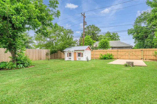 a view of a house with a yard and a large tree
