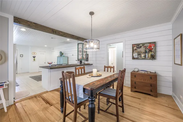 a dining room with furniture a chandelier and wooden floor