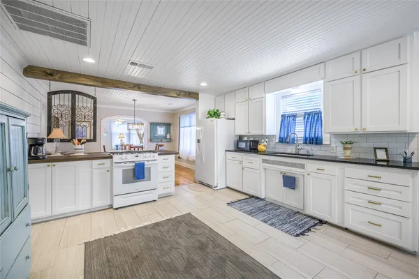 a kitchen with white cabinets and white appliances