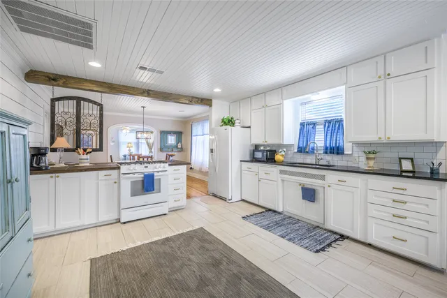 a kitchen with white cabinets and white appliances