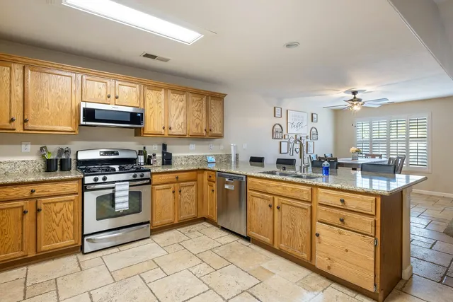 a kitchen with stainless steel appliances granite countertop a stove sink and cabinets